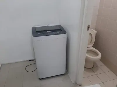 a bathroom with a washer and a toilet at Spacious 2 Bedroom Unit with Pool in Manila
