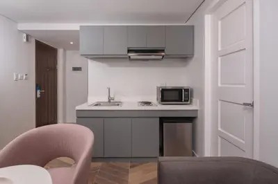 a small kitchen with a sink and a microwave at The Belamy House Managed by HII in Manila