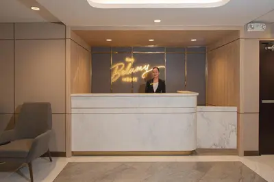 a woman standing at a counter in a hotel lobby at The Belamy House Managed by HII in Manila