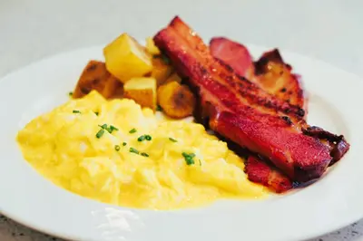a plate of food with eggs and bacon and potatoes at The Belamy House Managed by HII in Manila