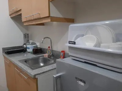 a kitchen with a sink and a dishwasher with plates at Family Staycation 2 with Pool in Manila