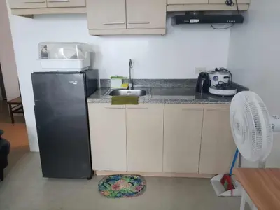 a kitchen with a black refrigerator and a sink at Family Staycation 2 with Pool in Manila