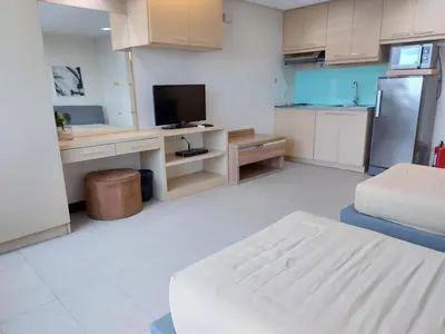 a room with a kitchen with a tv and a couch at Posh Beds with City View and Pools in Manila