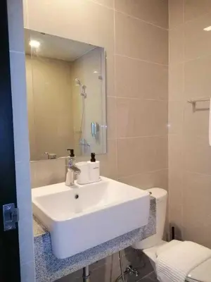 a bathroom with a white sink and a toilet at Uptown Parksuites Apartments Tower 1 BGC by PH Staycation in Manila