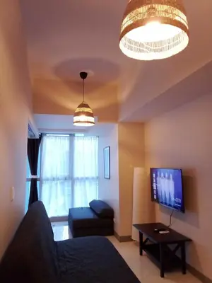 a living room with a couch and a tv at Uptown Parksuites Apartments Tower 1 BGC by PH Staycation in Manila