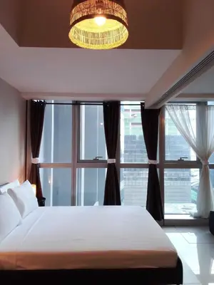 a bedroom with a bed and a large window at Uptown Parksuites Apartments Tower 1 BGC by PH Staycation in Manila
