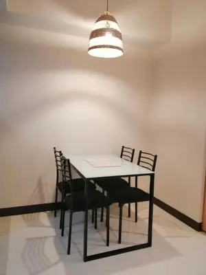 a dining room table with chairs and a light fixture at Uptown Parksuites Apartments Tower 1 BGC by PH Staycation in Manila