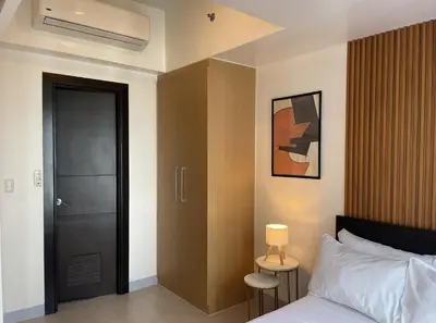 a bedroom with a bed and a door with a lamp at Uptown Parksuites Apartments Tower 1 BGC by PH Staycation in Manila