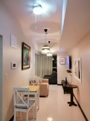 a living room with a table and a couch at Uptown Parksuites Apartments Tower 1 BGC by PH Staycation in Manila