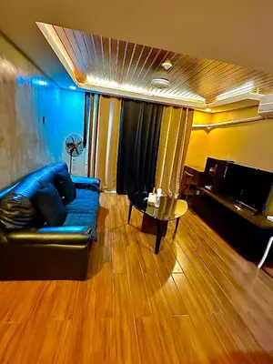 a living room with a blue couch and a table at IV’s Condo w/ Netflix and Wi-Fi in Cainta