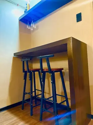 a wooden bar with two stools under a wall at IV’s Condo w/ Netflix and Wi-Fi in Cainta