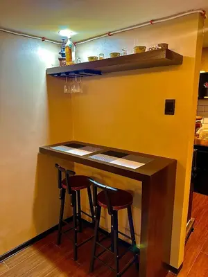 a bar in a kitchen with two stools at IV’s Condo w/ Netflix and Wi-Fi in Cainta