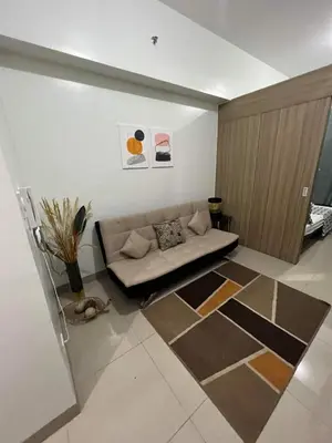 a living room with a couch sitting on the floor at SHORE TOWER 1 Staycation Near Mall Of Asia in Manila