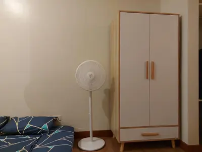 a bedroom with a fan next to a white cabinet at Flair Towers STUDIO ROOMS Staycation in Manila