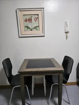 a table with four chairs and a picture on the wall at Sobere Unit in Manila