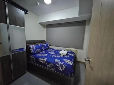 a small bedroom with a bed with a dog laying on it at Sobere Unit in Manila