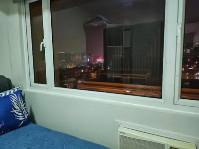 a window with a view of a city at night at Sobere Unit in Manila