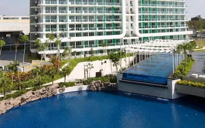 a large swimming pool in front of a large building at Azure Urban Resort Paris Beach Staycation in Manila
