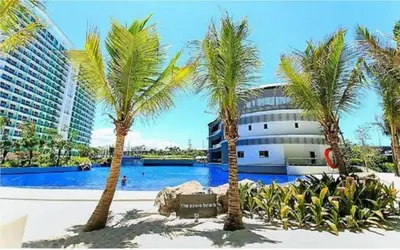 a group of palm trees in front of a building at Azure Urban Resort Paris Beach Staycation in Manila