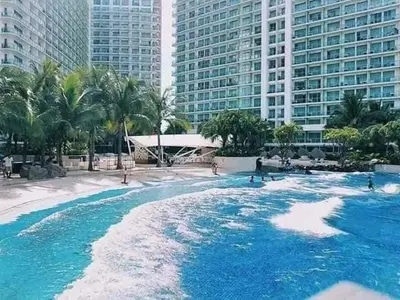 a swimming pool with blue water in front of buildings at Azure Urban Resort Paris Beach Staycation in Manila