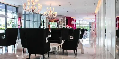 a dining room with black chairs and a table and chandeliers at Azure Urban Resort Paris Beach Staycation in Manila