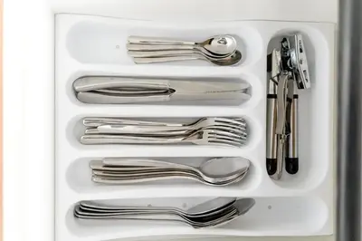 a white tray with silver utensils in a drawer at Stylish loft, 65 in UHDTV w Fast WiFi + Pool & Gym in Manila