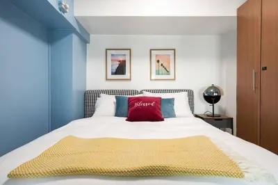 a bedroom with a large bed with a red pillow at Stylish loft, 65 in UHDTV w Fast WiFi + Pool & Gym in Manila