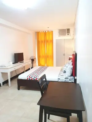 a bedroom with a bed and a desk and a table at SAB R.CONDOTEL and room rental in Manila