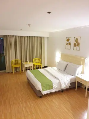 a bedroom with a bed and two tables and chairs at SAB R. CONDOTE'L SUITES in Manila