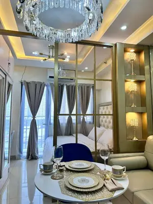 a room with a bed and a table with wine glasses at Deluxe Suites Razelles 2 at Shore 2 Residences Tower 1 in Manila
