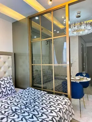 a bedroom with a bed and a table and a mirror at Deluxe Suites Razelles 2 at Shore 2 Residences Tower 1 in Manila