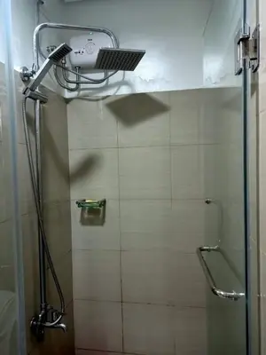 a shower with a shower head in a bathroom at Deluxe Suites Razelles 2 at Shore 2 Residences Tower 1 in Manila