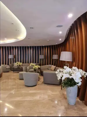 a living room with couches and tables and flowers at Deluxe Suites Razelles 2 at Shore 2 Residences Tower 1 in Manila