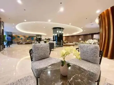 a lobby with two chairs and a table with flowers on it at Deluxe Suites Razelles 2 at Shore 2 Residences Tower 1 in Manila