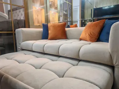 a couch with orange and blue pillows on it at Deluxe Suites Razelles 2 at Shore 2 Residences Tower 1 in Manila