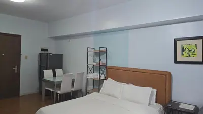 a bedroom with a bed and a table with chairs at ETON BAYPARK MANILA by TRIPLE VIEW CONDOTEL in Manila