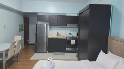 a kitchen with a refrigerator and a table in a room at ETON BAYPARK MANILA by TRIPLE VIEW CONDOTEL in Manila