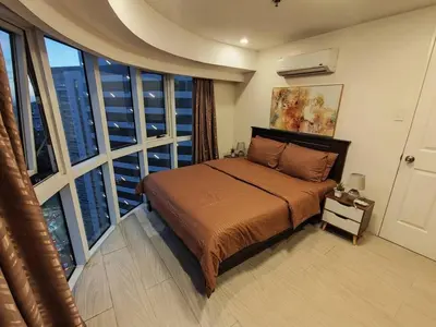 a bedroom with a bed and a large window at A2J Luxury 2BR Suite Near High Street BGC Taguig in Manila
