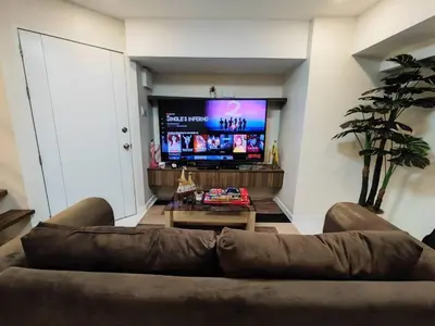 a living room with a couch and a flat screen tv at A2J Luxury 2BR Suite Near High Street BGC Taguig in Manila