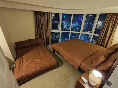 a bedroom with two beds and a large window at A2J Luxury 2BR Suite Near High Street BGC Taguig in Manila