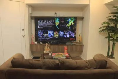 a living room with a couch and a flat screen tv at A2J Luxury 2BR Suite Near High Street BGC Taguig in Manila