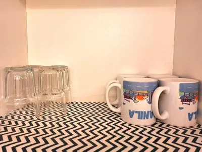 two coffee mugs sitting on a table with glasses at Best staycation at Shell residences in MOA complex in Manila