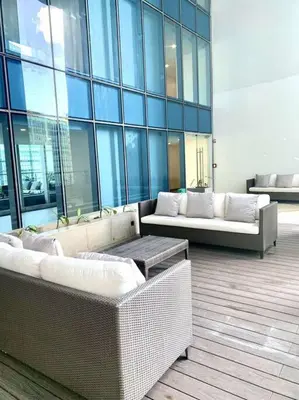 a lobby with two couches and a table in a building at Cosy Executive 1 BR Uptown Parksuites Ultra fast Internet in Manila
