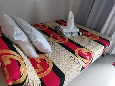 a bed with a table with a night stand on it at Sea Residences Staycation Tanya's Condo Pasay in Manila