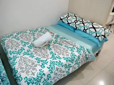 a bed with blue and white sheets and pillows at Sea Residences Staycation Tanya's Condo Pasay in Manila
