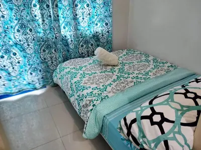 a small bedroom with a bed with a blue and white blanket at Sea Residences Staycation by TVANS CONDOTEL Pasay City in Manila
