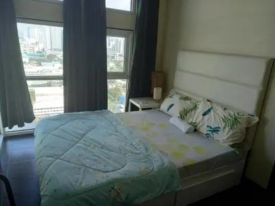 a bedroom with a bed with a large window at SLP Montecillo in Manila