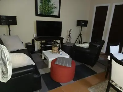 a living room with a couch and chairs and a television at SLP Montecillo in Manila