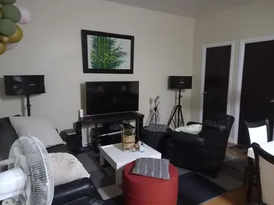a living room with black furniture and a flat screen tv at SLP Montecillo in Manila