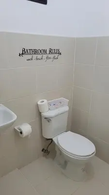 a bathroom with a toilet and a sink at Camilyn Home Stay in General Trias